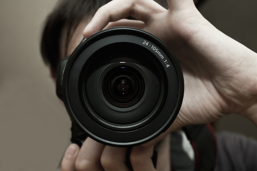 A photographer adjusts his lens