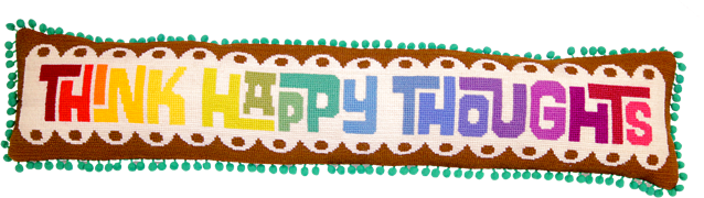 long rectangular cushion with the phrase think happy thoughts in rainbow needlepoint