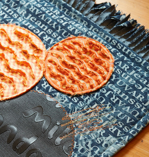 Denim rug with applique and embroidery.