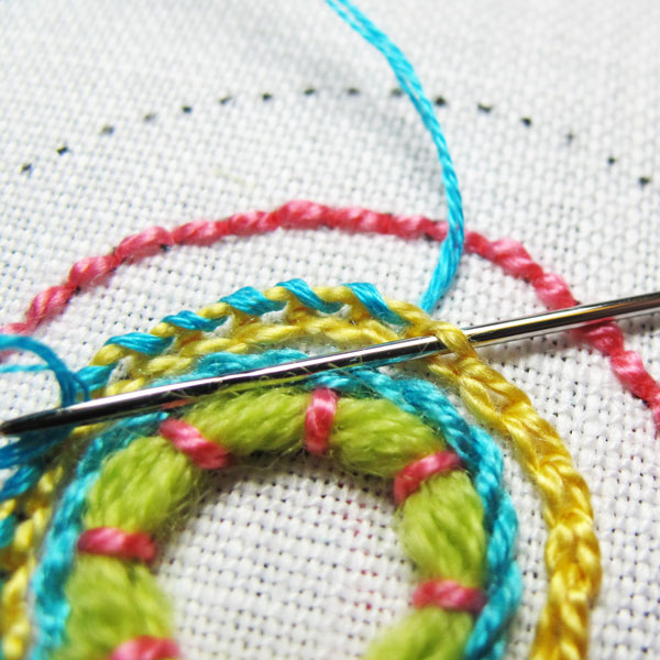 Using a tapestry needle and whipped the outer loops on the chain stitch 