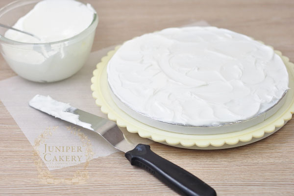 Add royal icing to a cake board for a rustic snow effect