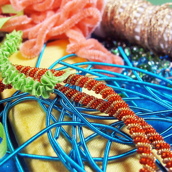 Fabric, ribbon, beads and specialty threads help add dimension and texture to embroidery.