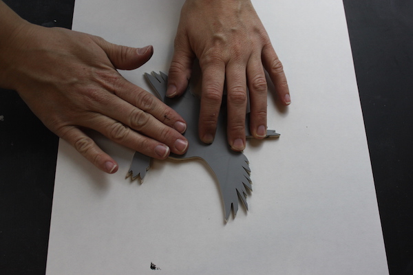 Pressing bird stamp on paper