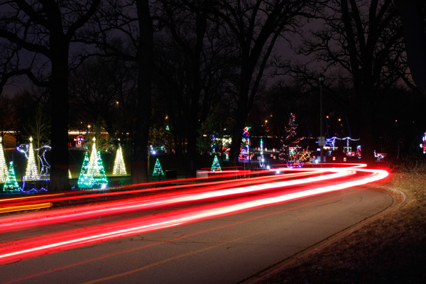 Light trails from passing traffic driving through a Christmas light display