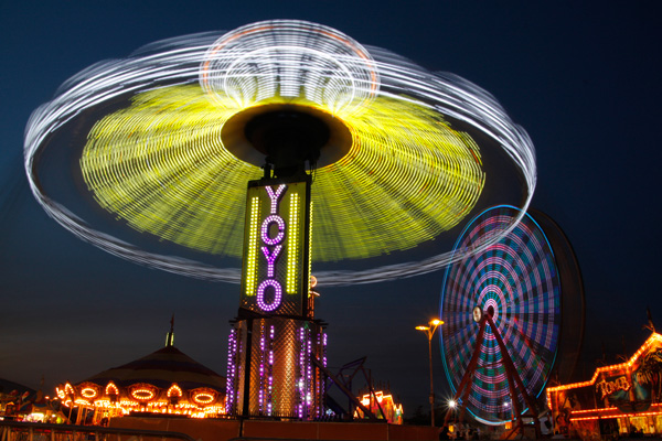 Twilight carnival rides including the swings and a Ferris wheel