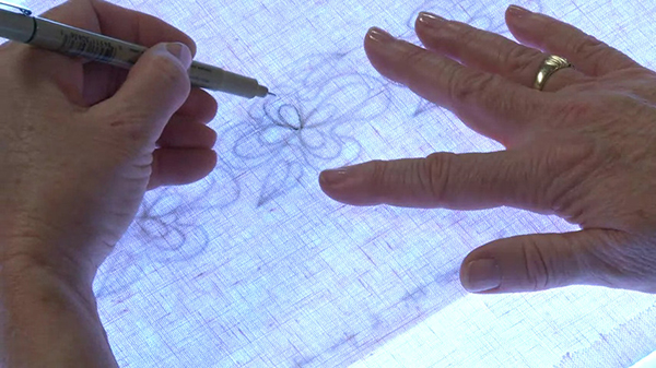 Tracing embroidery designs on fabric.