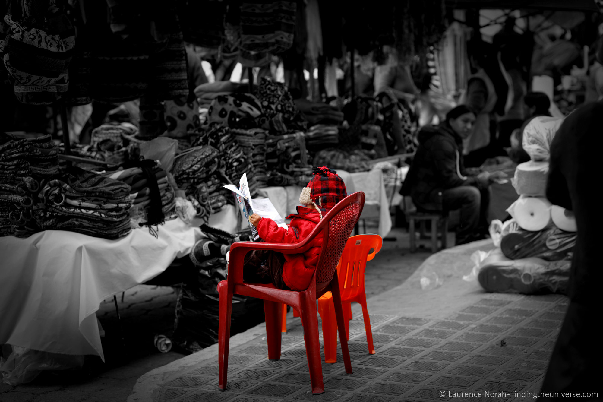 Boy reading paper Otavalo market Ecuador scaled