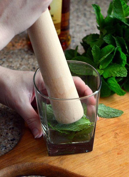 Muddling Mint for a Assembling a Classic Mint Julep Cocktail