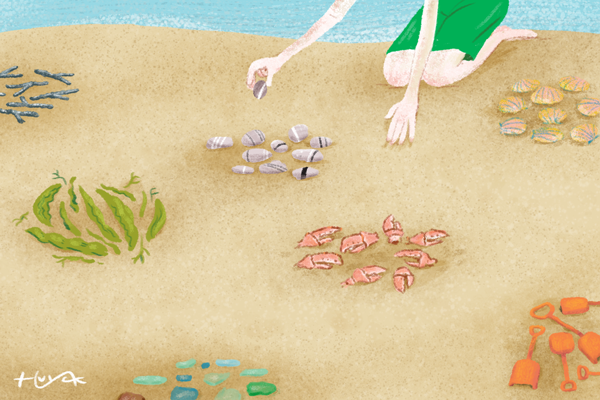 A child collects clusters of objects from the beach