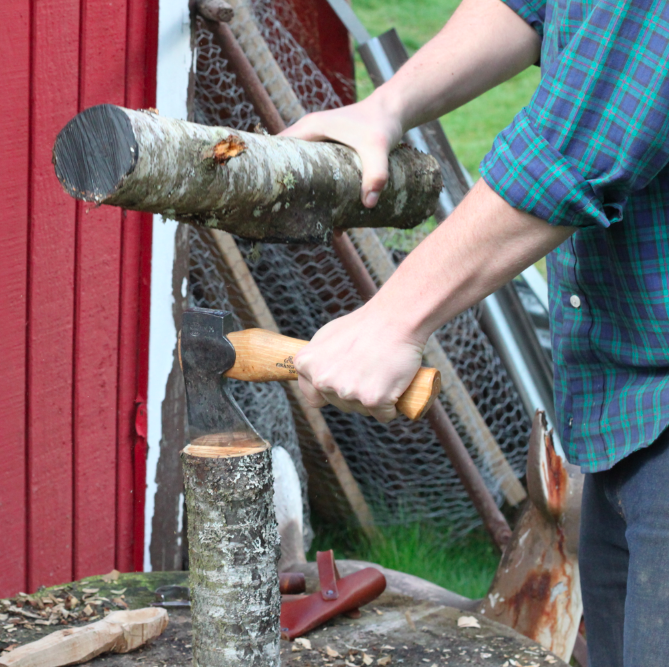 hatchet in the center of log over the pith (dark center), striking the hatchet with a mallet or another branch