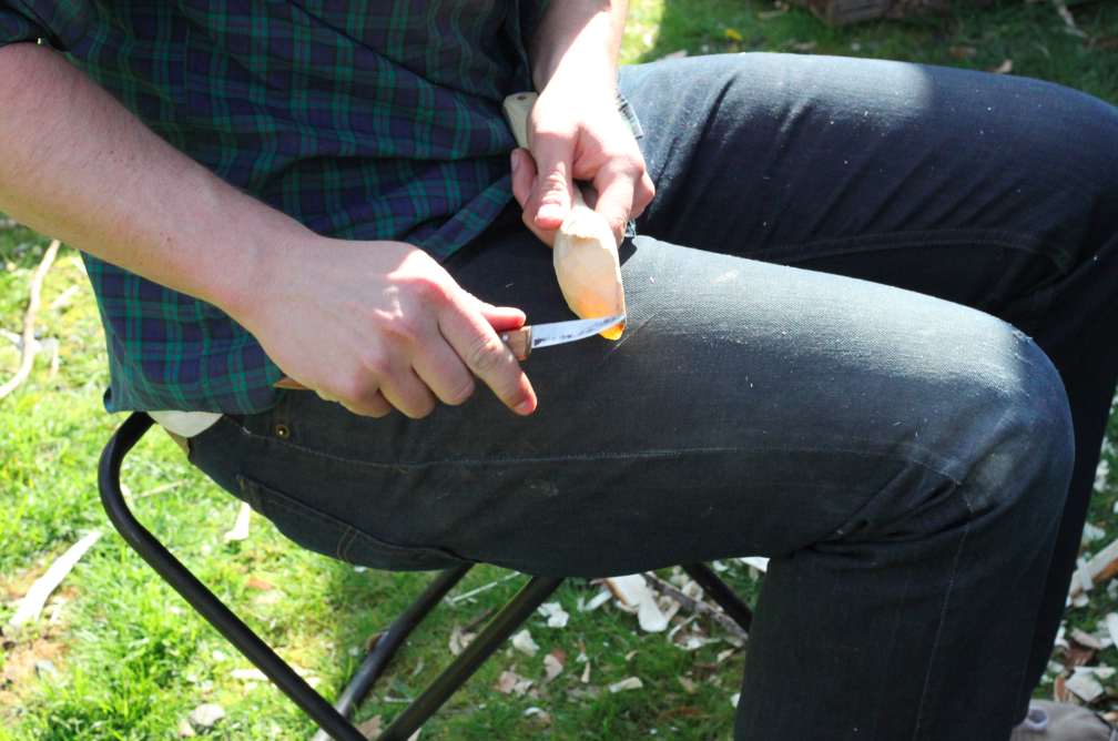 refining the shape of the tip of the spoon with a carving knife