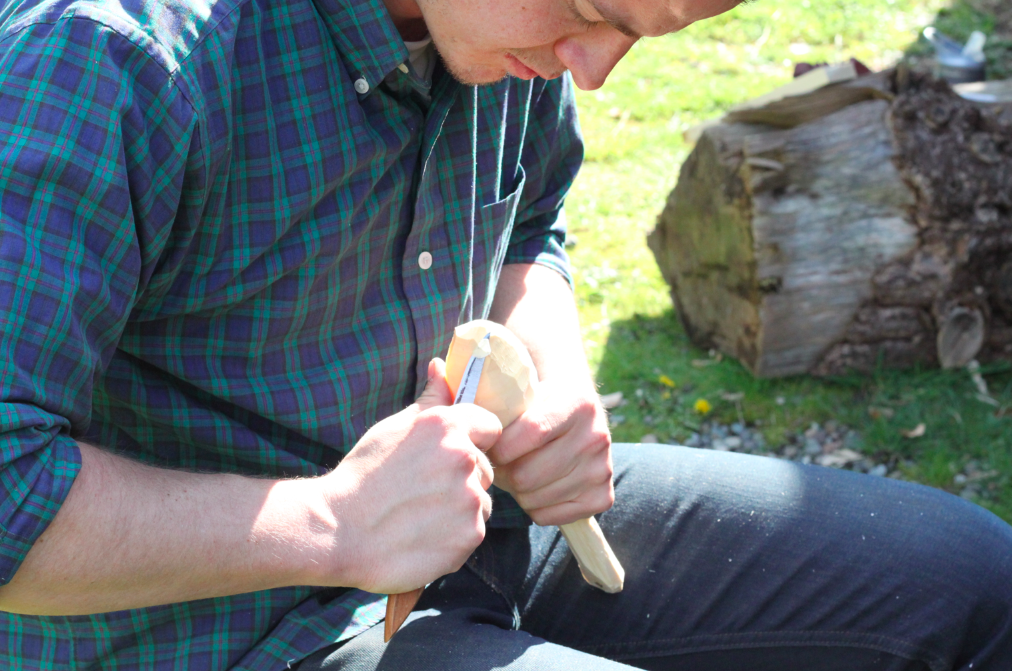 finishing refining the shape of the spoon with a carving knife