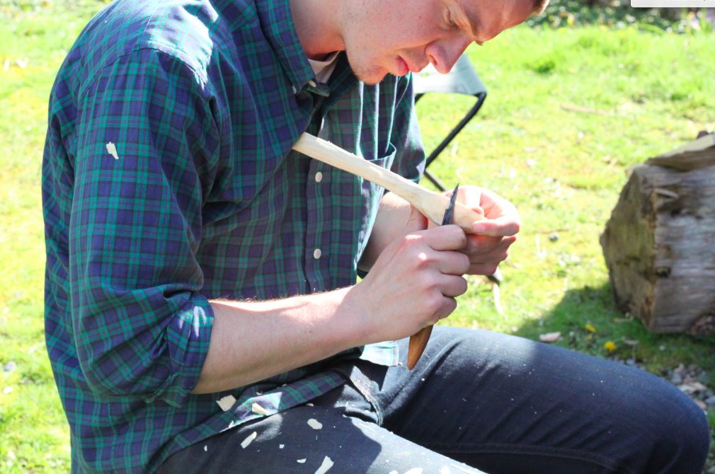 refining the base of the bowl of the spoon with a carving knife