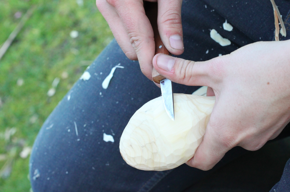 refining the back of the spoon using a carving knife