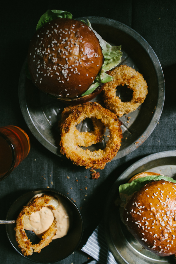 Burgers and onion rings on plates