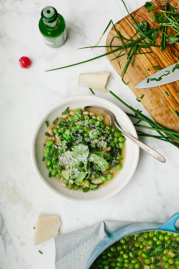 bowl of pea soup next to a cutting board