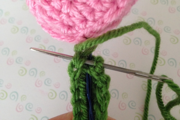 Sewing on the stem of a crocheted tulip