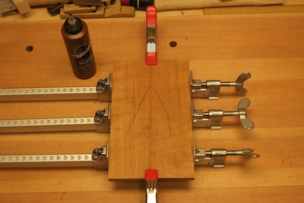 Panel of wood held with spring clamps for glue up