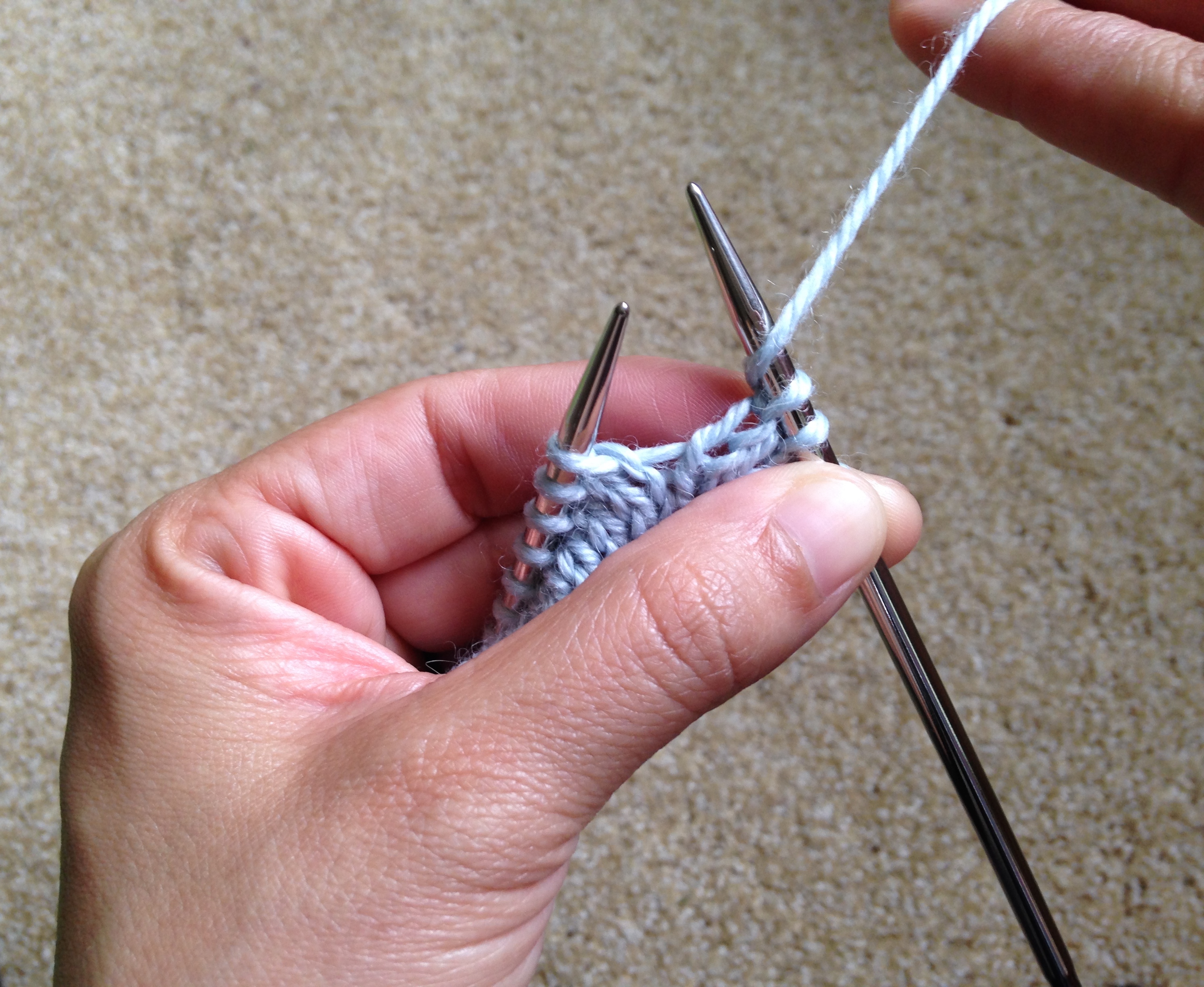 Wrapping yarn around a needle for a yarn over