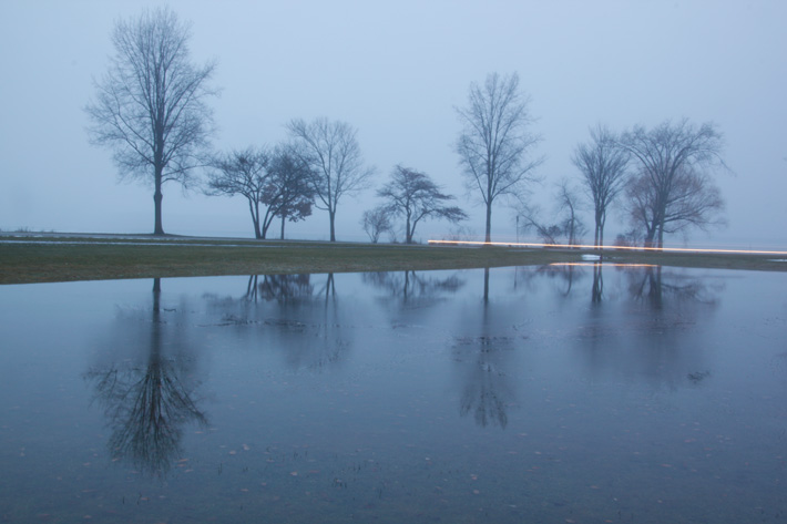 Foggy reflection shot of lake with light trail