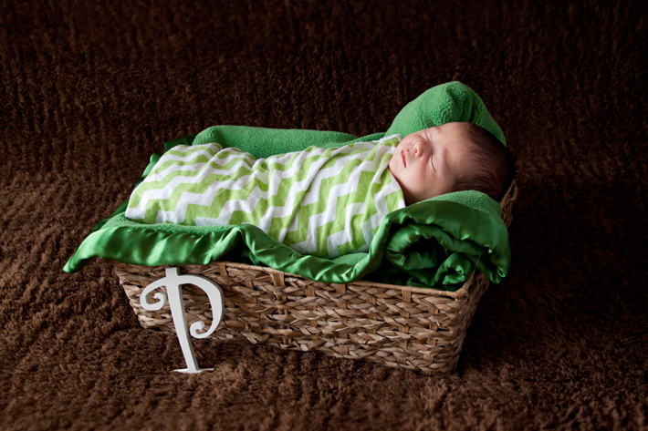 Newborn photography props shown including basket, wooden letters, and backdrop