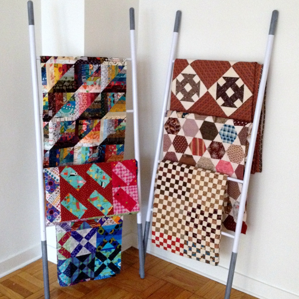 Finished quilts displayed on towel racks