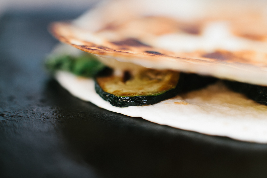 A close up of a zucchini, basil and gruyere quesadilla