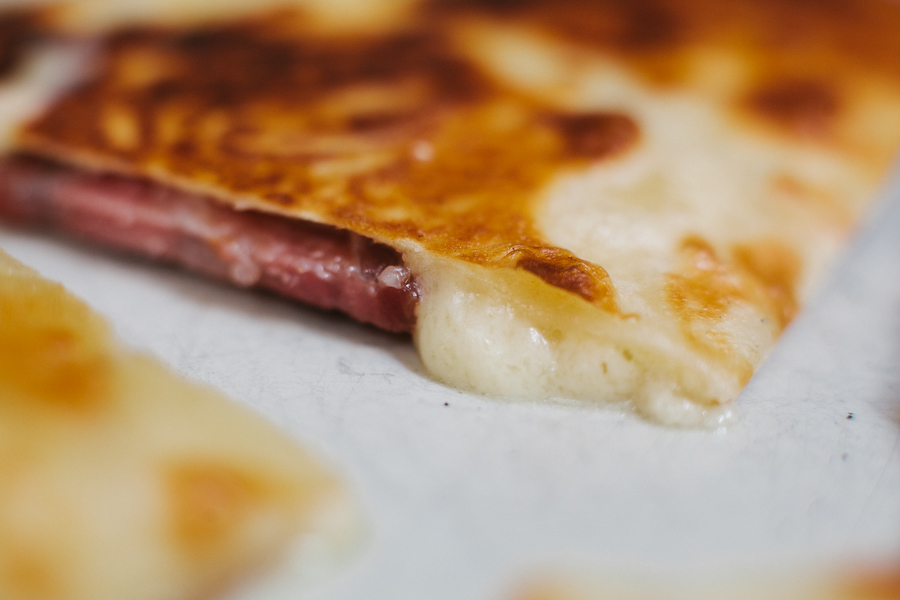 Melting sharp cheddar along with salami