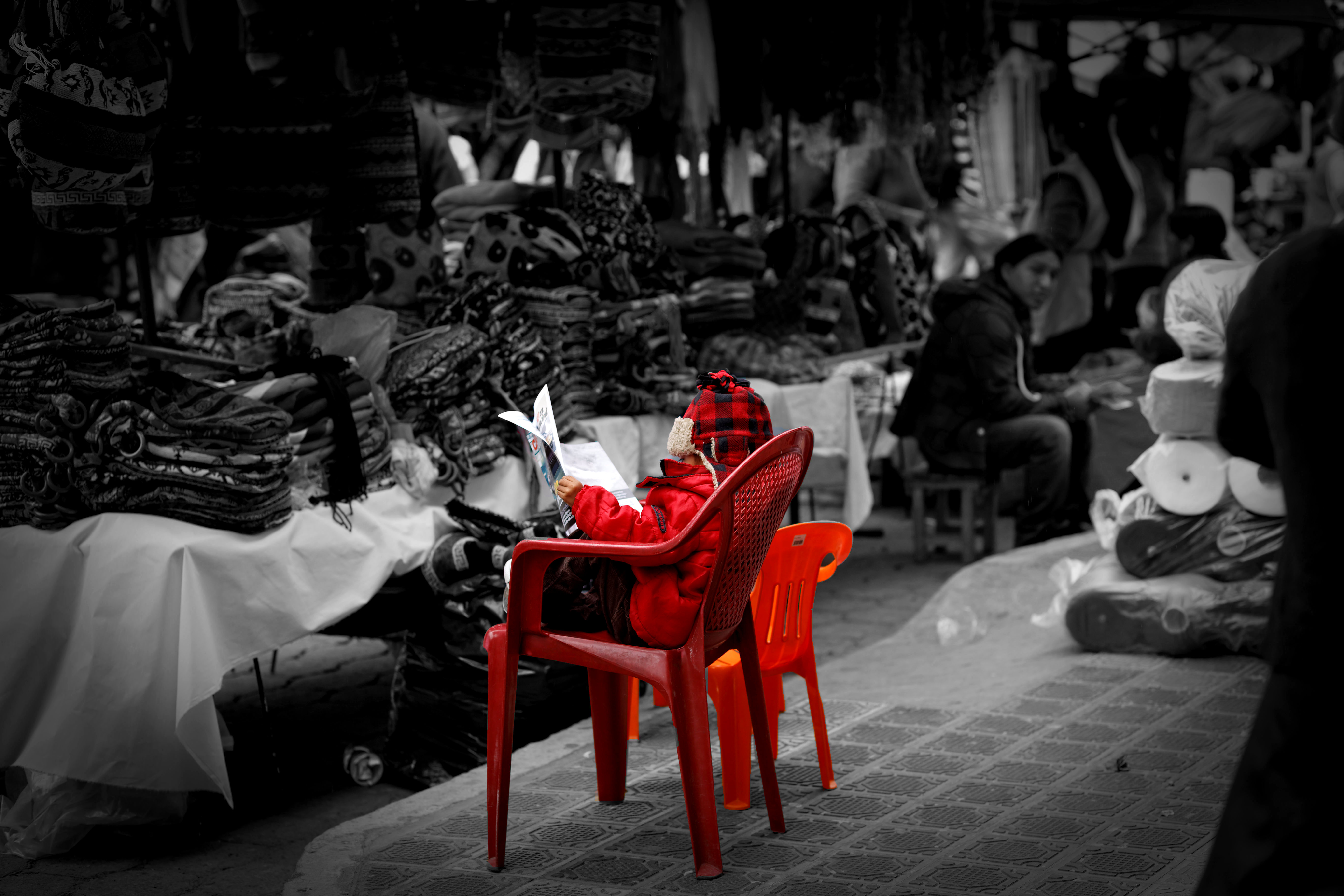 Boy reading paper Otavalo market Ecuador