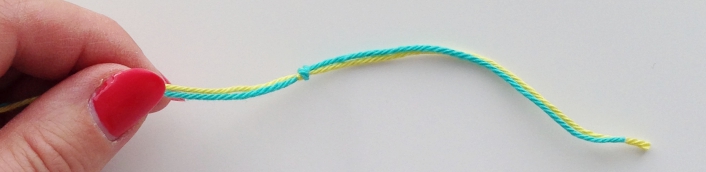 Tie a knot in the extender thread for the hairpin lace