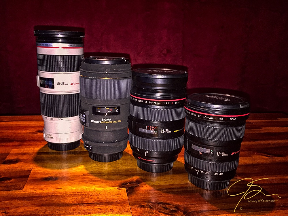 Four camera lenses used for nature and landscape photography