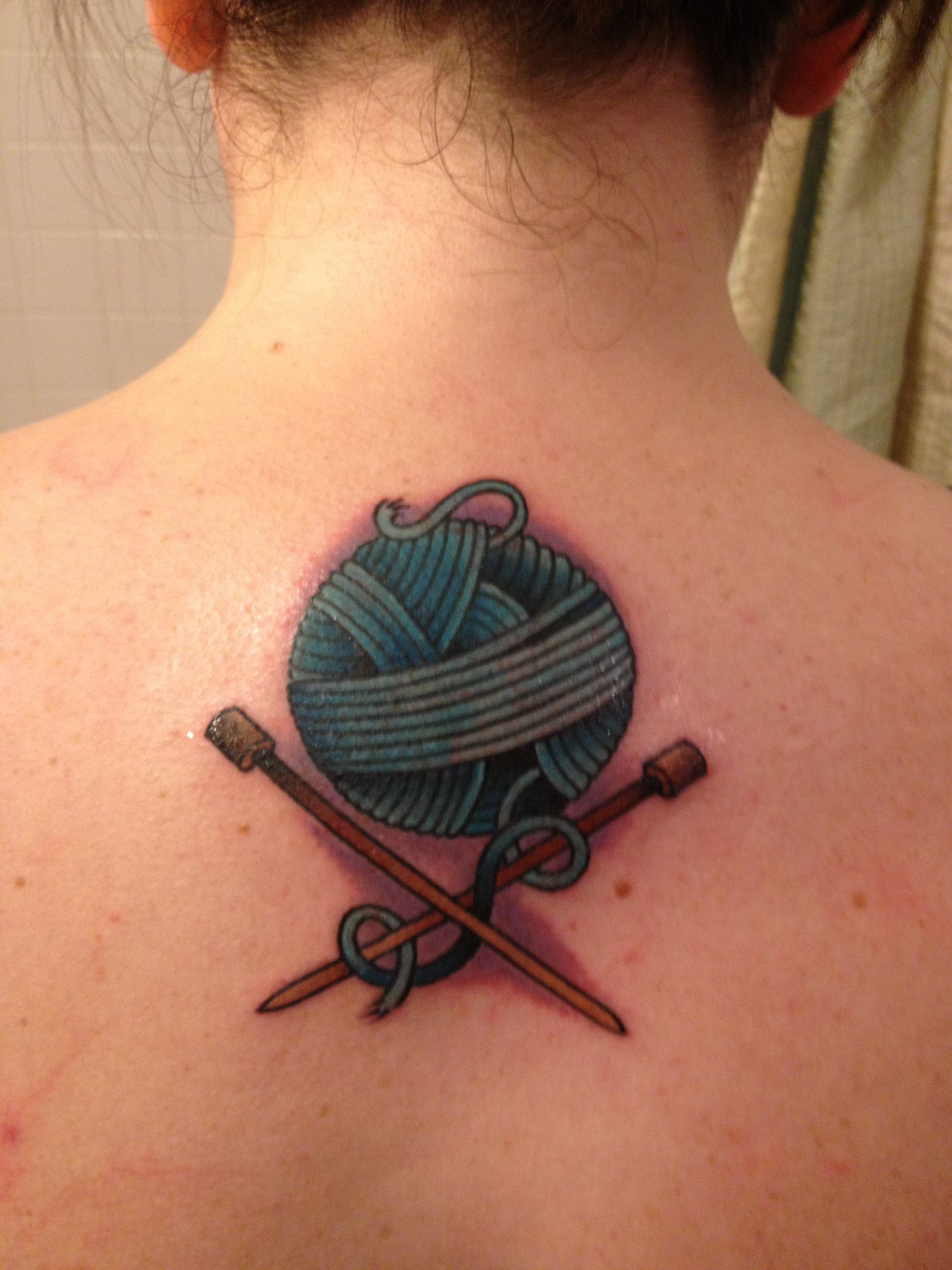 Knitting tattoo with needles and a ball of yarn