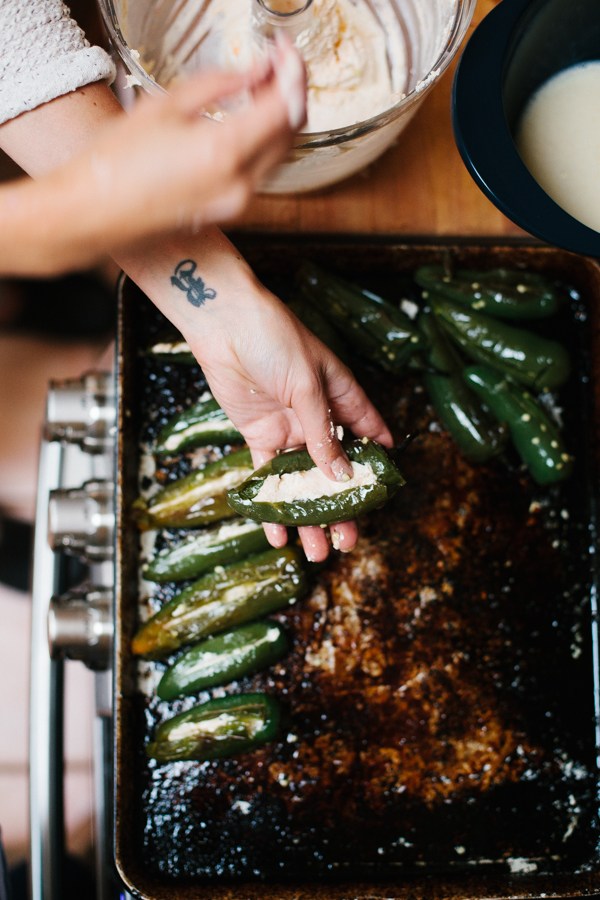stuffing jalapeños with cheese to make homemade jalapeño poppers