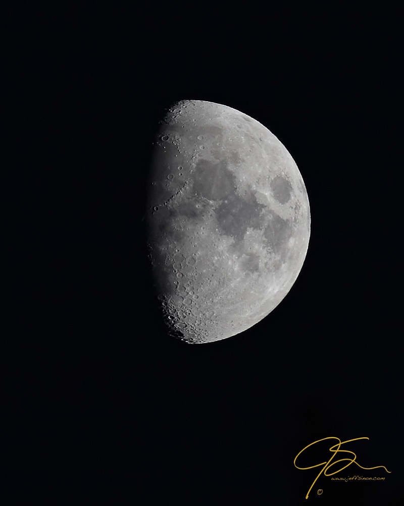 three quarter moon in the dark night sky
