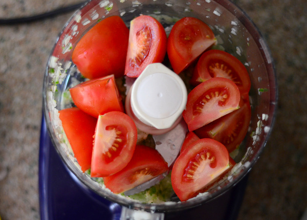 Adding tomatoes to food processor salsa