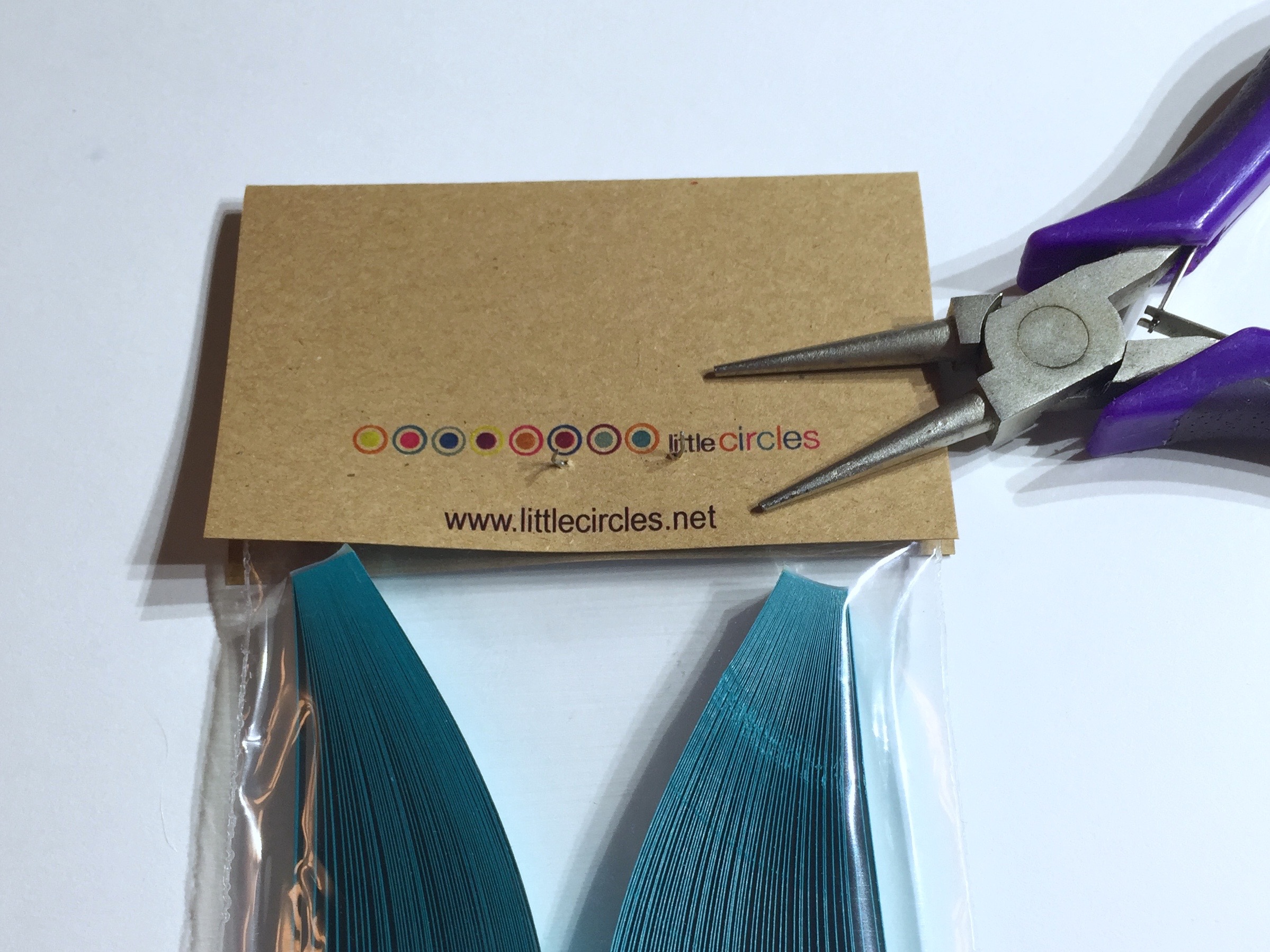 Image of taking staple out of a pack pf quilling strips lablel