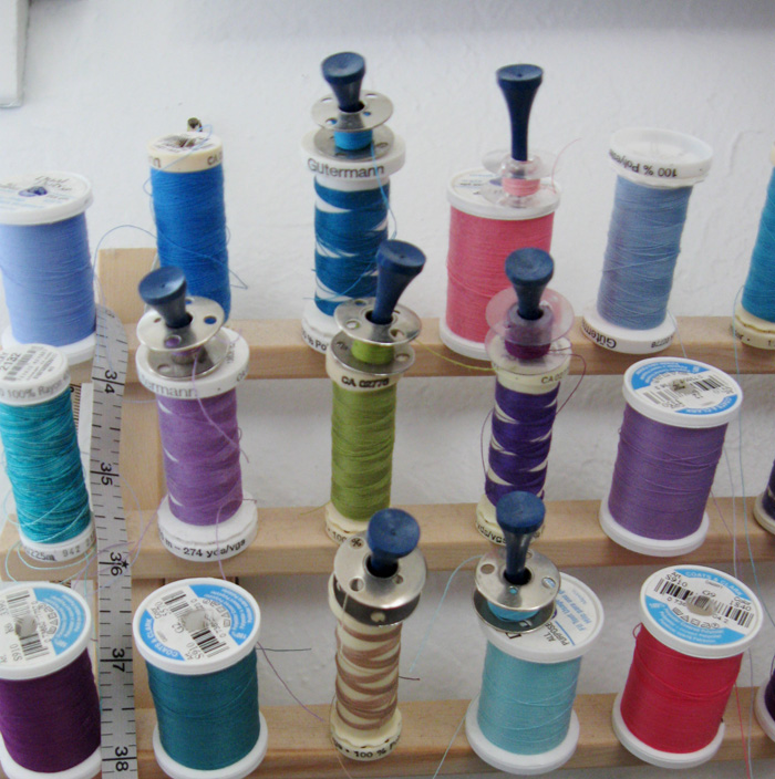 golf tees holding bobbins on thread
