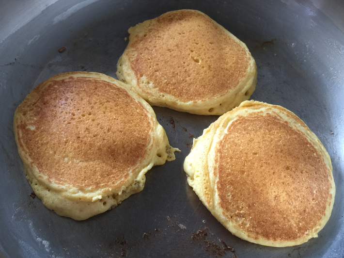 Cooked Cornbread Pancakes on a Hot Skillet
