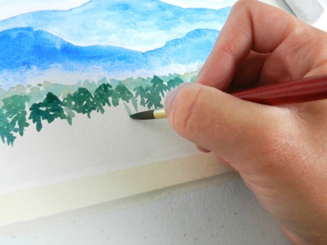 Small watercolor trees add scale to a mountain painting