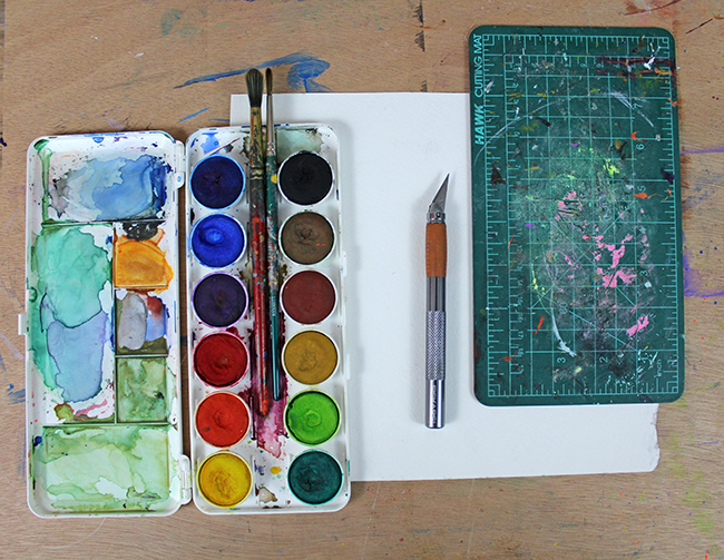 watercolor supplies and knife for cut out art