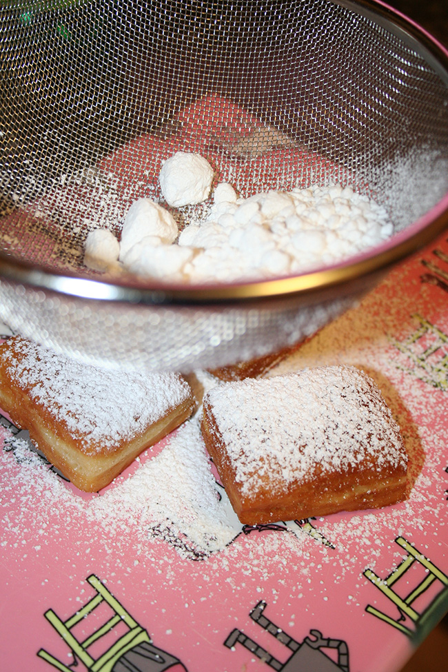 Beignets being dusted with sugar