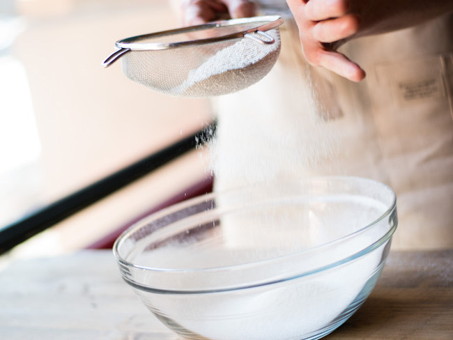 Sifting Flour Into a Glass Bowl