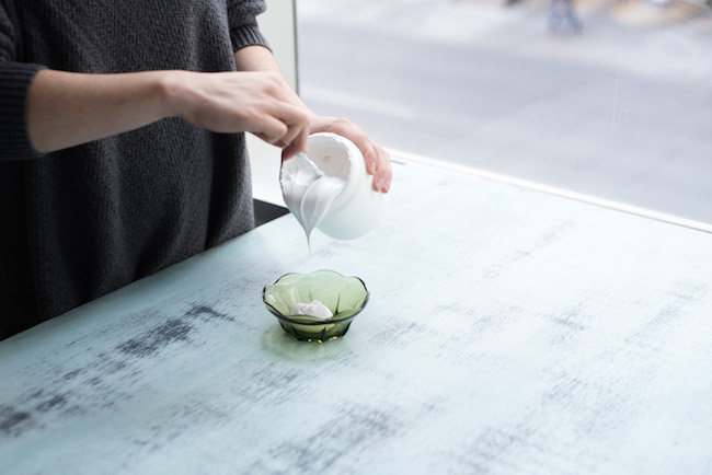 pouring gesso into a small green bowl