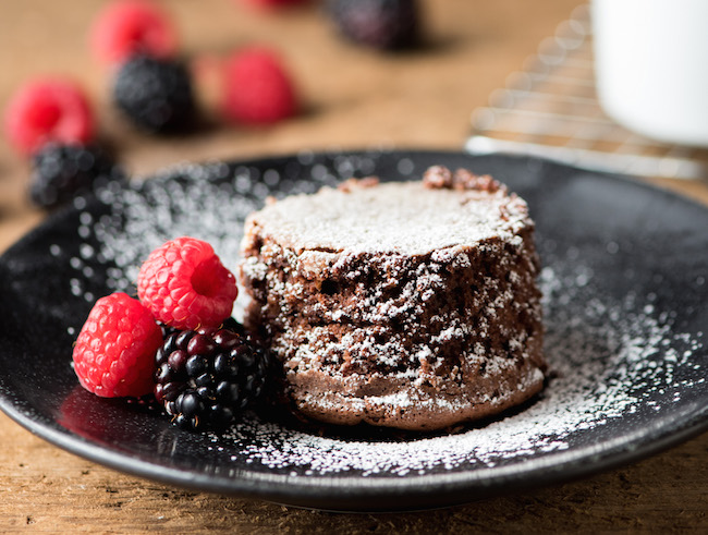 Single serve chocolate cake with berries and powdered sugar