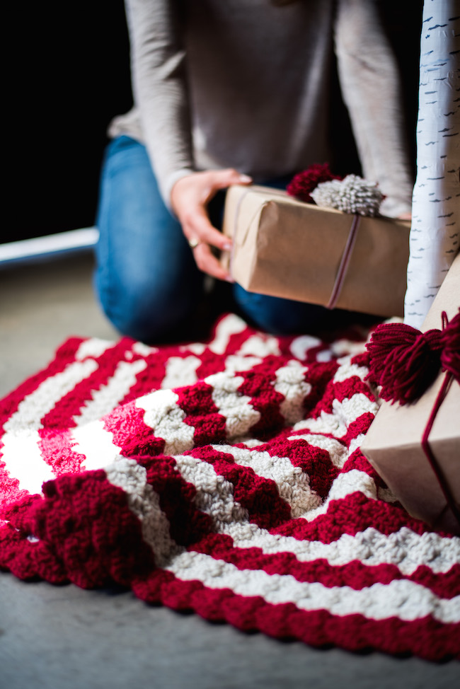 Placing Gifts under the tree with crochet tree skirt