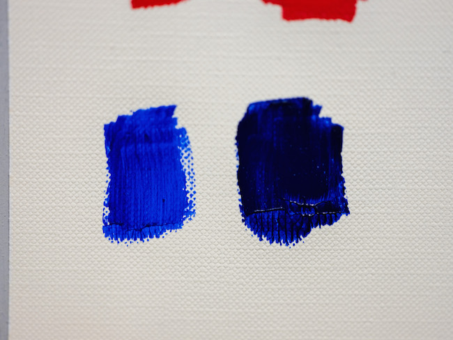 Blue paint from the tube next to blue paint mixed with a touch of red