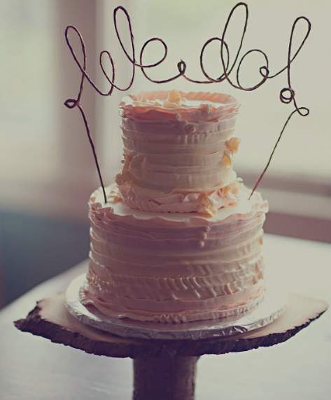 Tiered Pink Cake with Topper Reading "We Do"