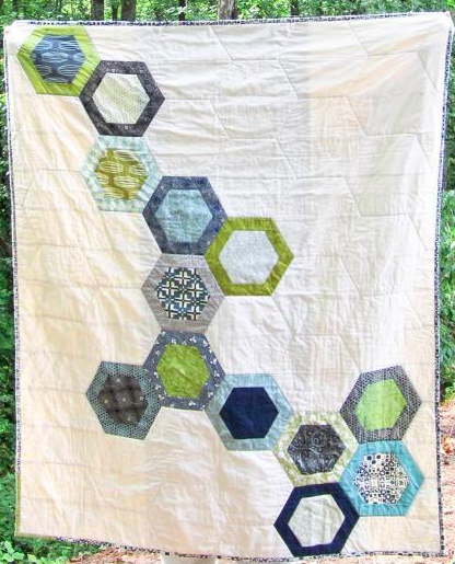 white quilt featuring colored hexagons