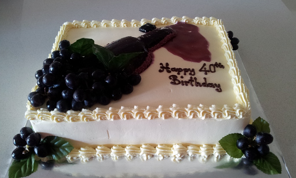 Rectangular White Cake Topped with Spilling Wine Bottle and Grapes