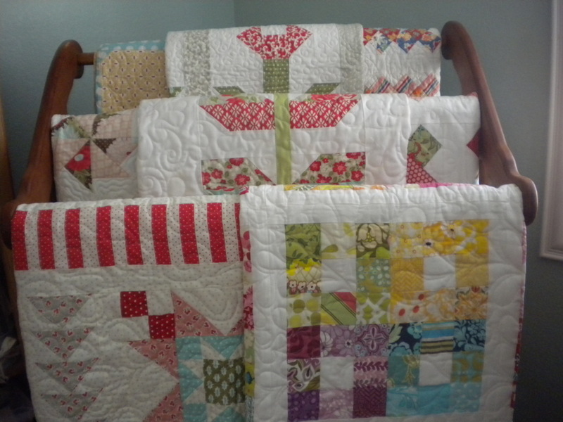 Multiple Quilts Hanging on a Wooden Rack